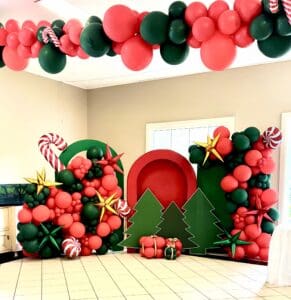 Christmas Themed Party Backdrop display with arches, Christmas tree cut outs and balloons